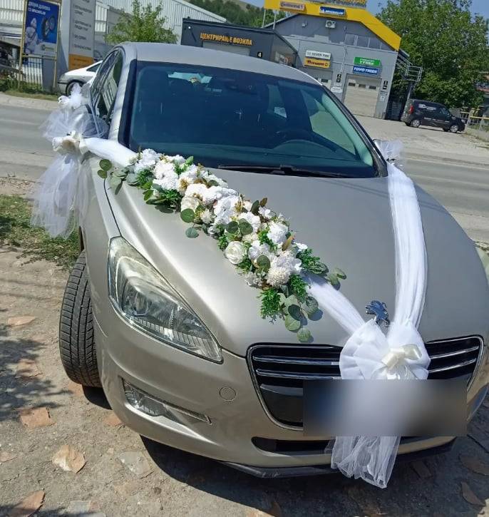 Свадбена декорација на автомобил: бели цвеќиња и тул по хаубата и бела машна напред